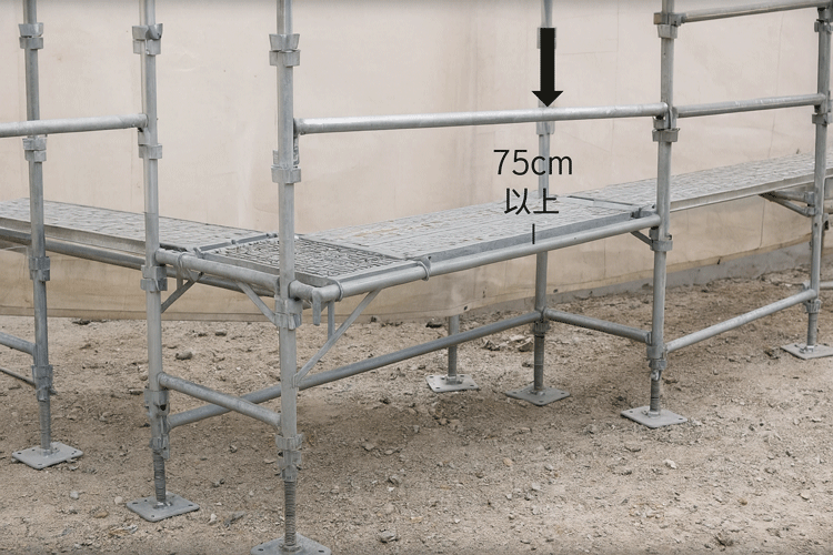 ブラケットに布板を設置し、作業床の高さを75cm以上に確保したクサビ式足場の写真