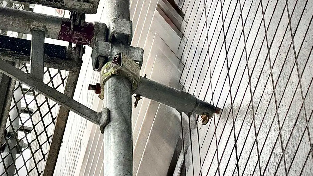 外壁タイル面に固定された壁つなぎ金具とクサビ足場の接続部の実例写真