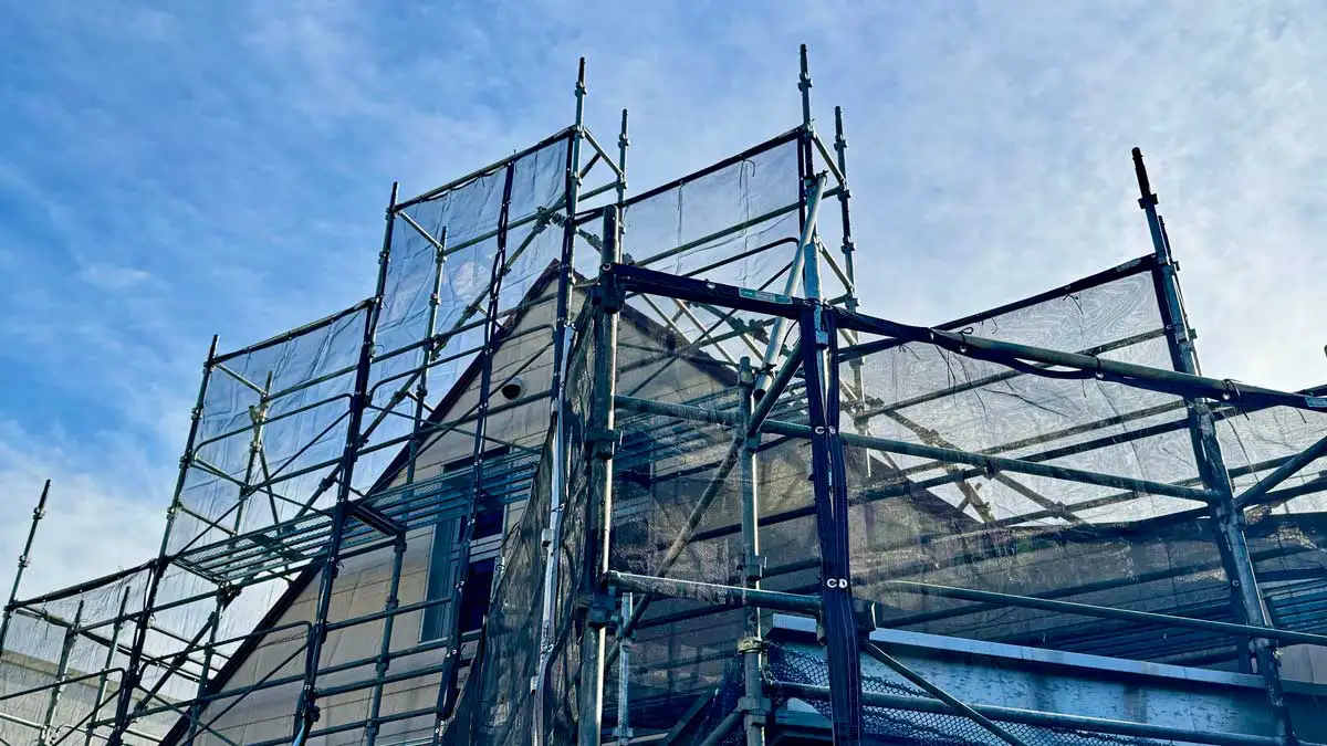 住宅外壁に設置された一側足場と補強材の全景写真。クサビ足場とブラケット足場の違いを説明するための現場写真。